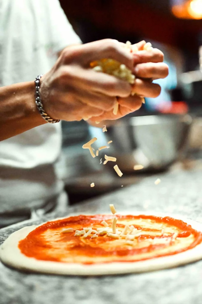 Préparation d'une pizza dans le restaurant Acquarossa, prise en photo par l'agence Cocobolo