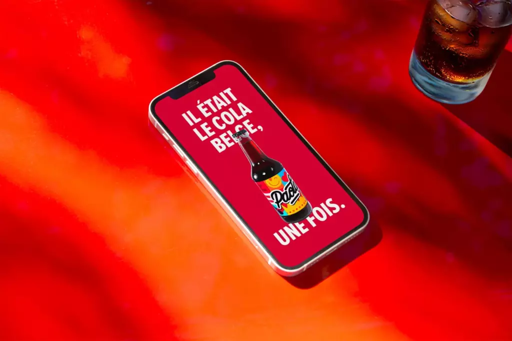 Smartphone affichant « Il était le cola belge, une fois »