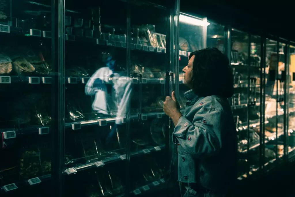 Cliente devant un frigo, un zombie dans le reflet