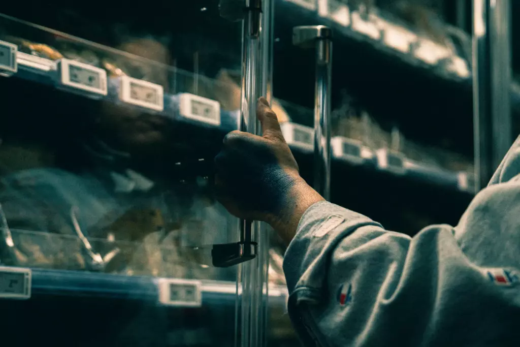 Main tachée de bleu qui ouvre un frigo