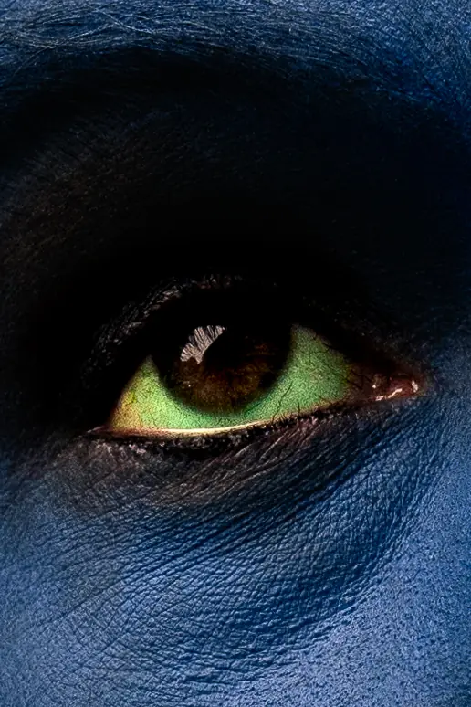Œil vert dans un visage bleu