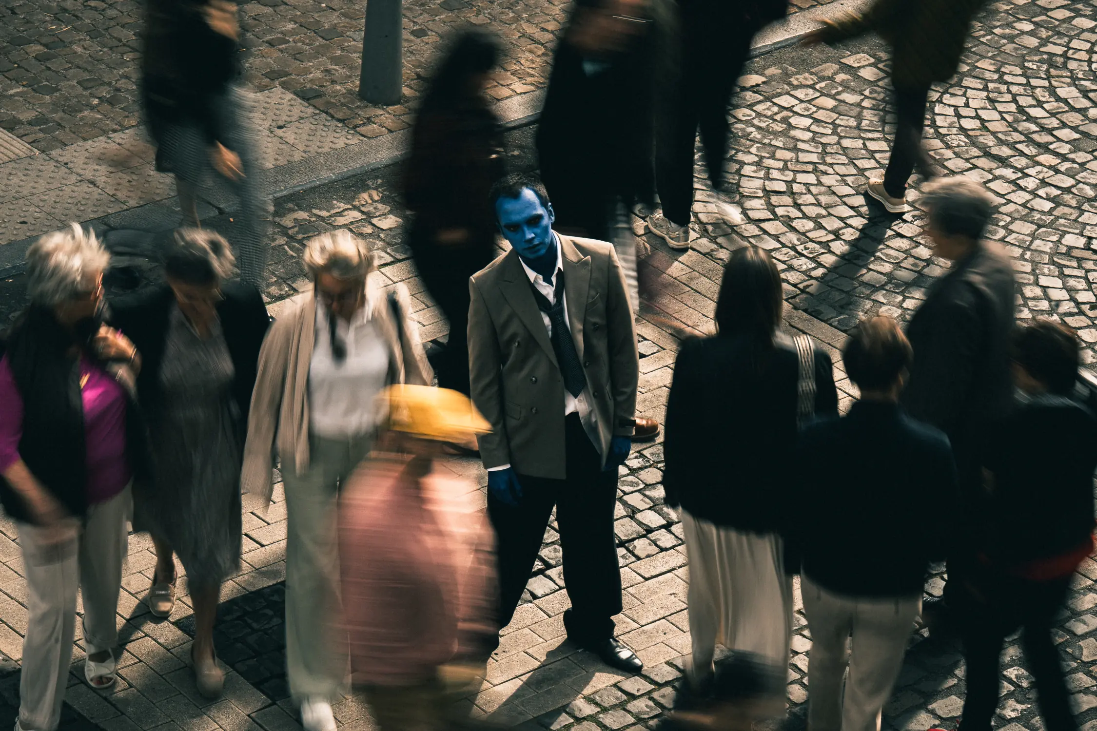 Foule sur un passage piéton à Liège, un zombie au milieu