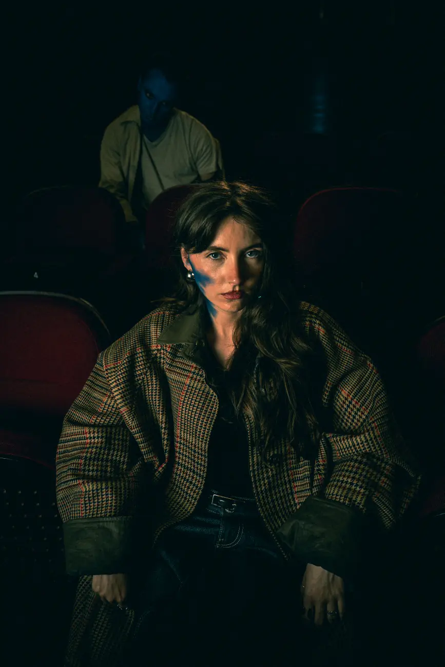 Spectatrice assise, zombies au fond de la salle