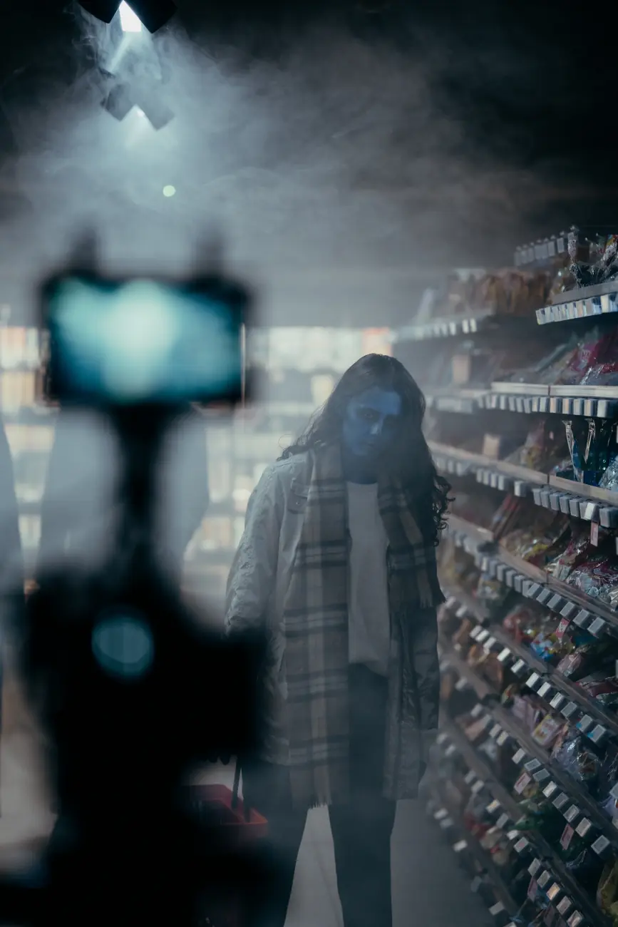 Caméra qui filme une zombie entre les rayons
